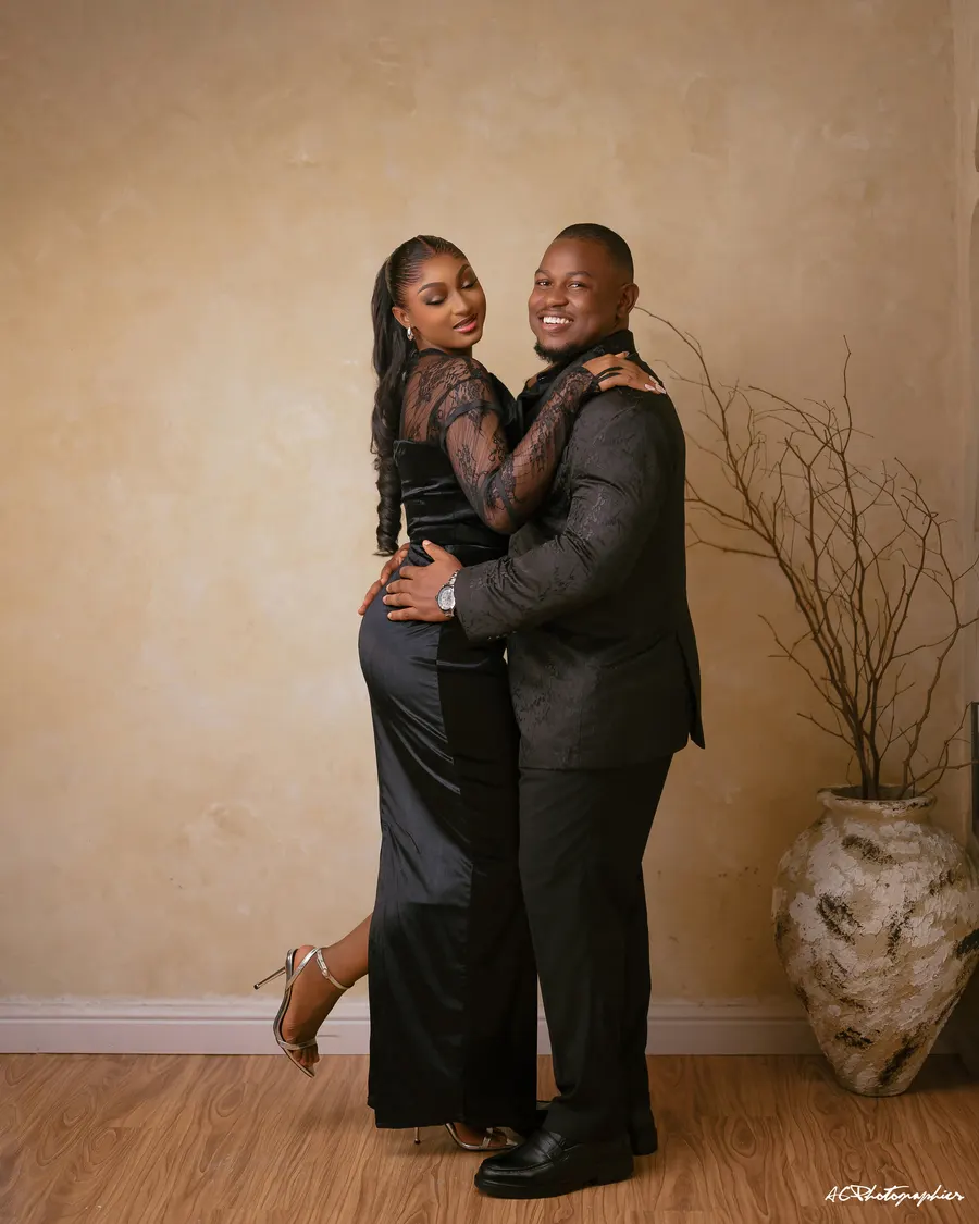 Kelvin and Emma embracing in black evening wear